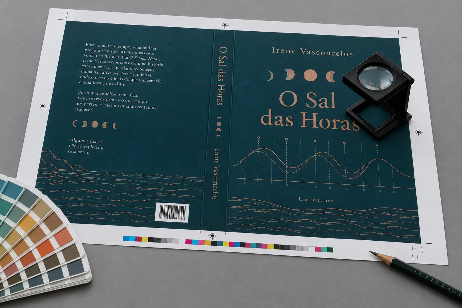 Prova de impressão de uma capa de livro com marcas de corte e barra de controle de cor, conta-fios e leque de cores sobre a mesa